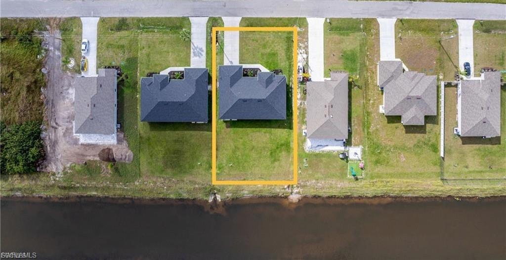 Aerial perspective of suburban area featuring a large body of water