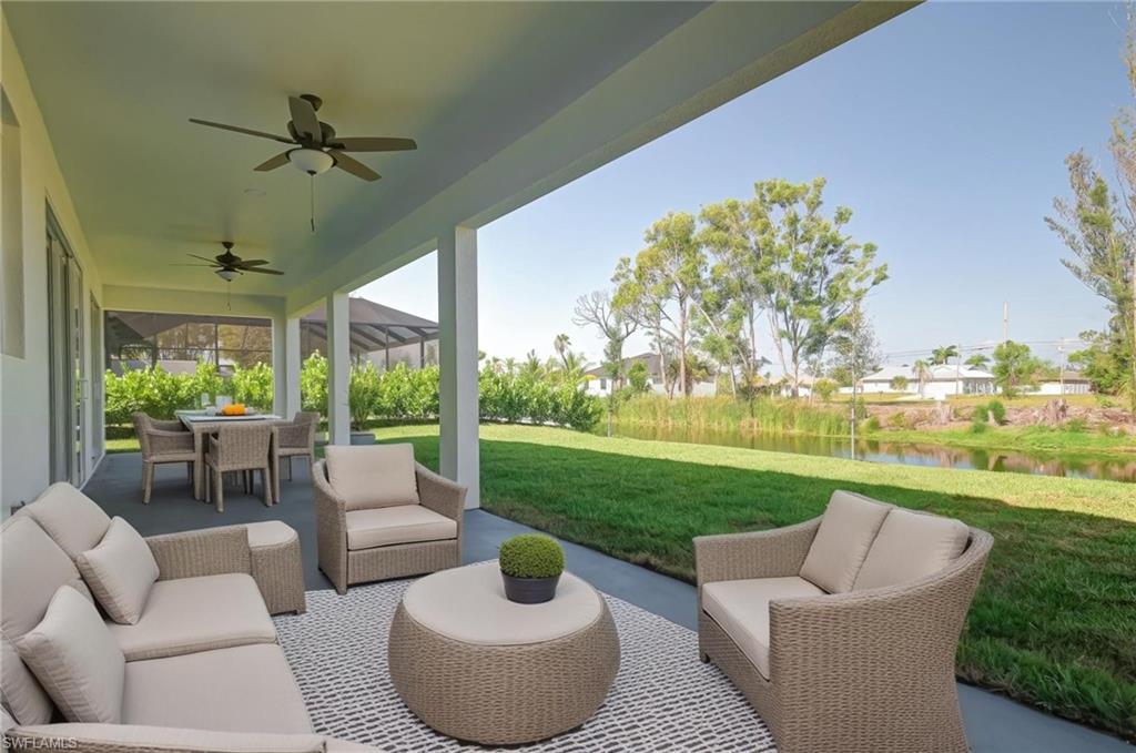 View of patio with an outdoor living / dining area, a water view, and ceiling fan