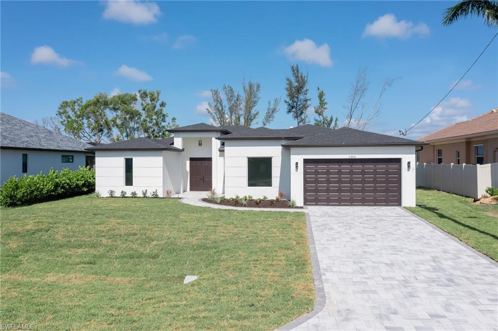 Prairie-style home featuring stucco siding, driveway, and an attached garage