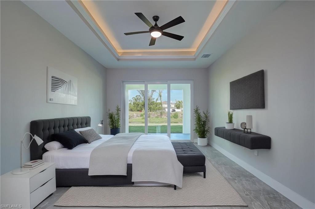 Bedroom featuring access to outside, a ceiling fan, and a tray ceiling