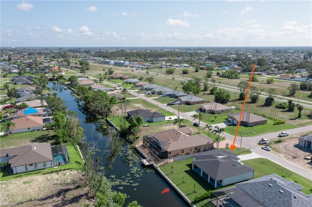 Aerial view of residential area featuring a nearby body of water