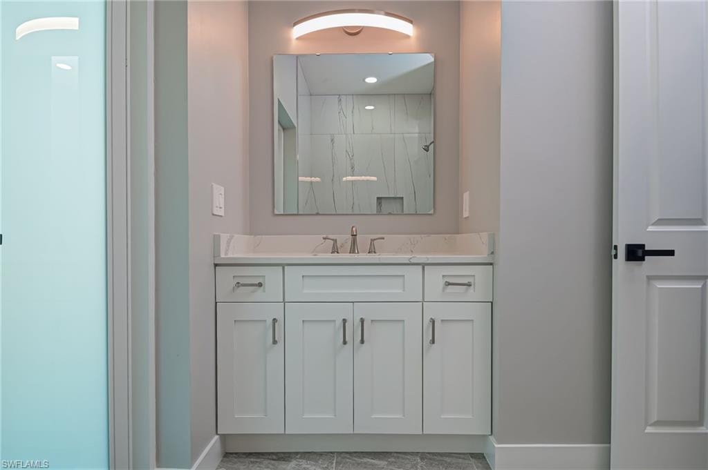 Full bath with vanity and a marble finish shower