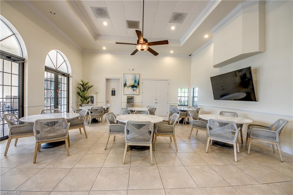 Dining room with crown molding, ceiling fan, recessed lighting, light tile patterned flooring, and french doors