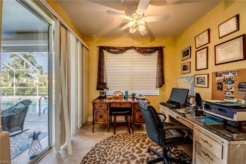 Office space with a ceiling fan and light tile patterned floors