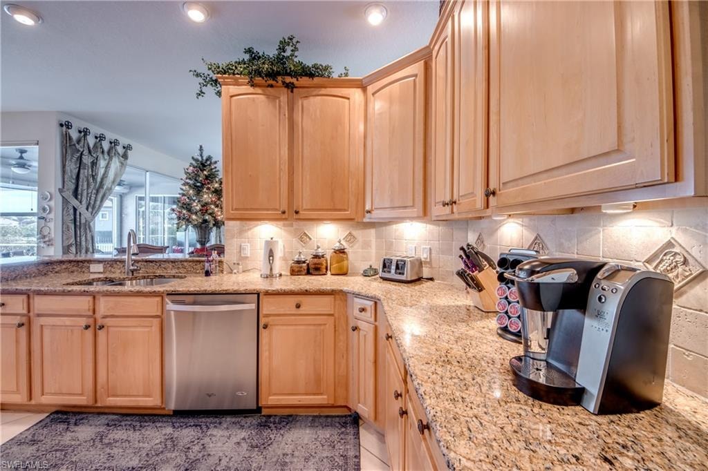 Kitchen featuring light wood finish cabinets, dishwasher, backsplash, light stone counters, and recessed lighting