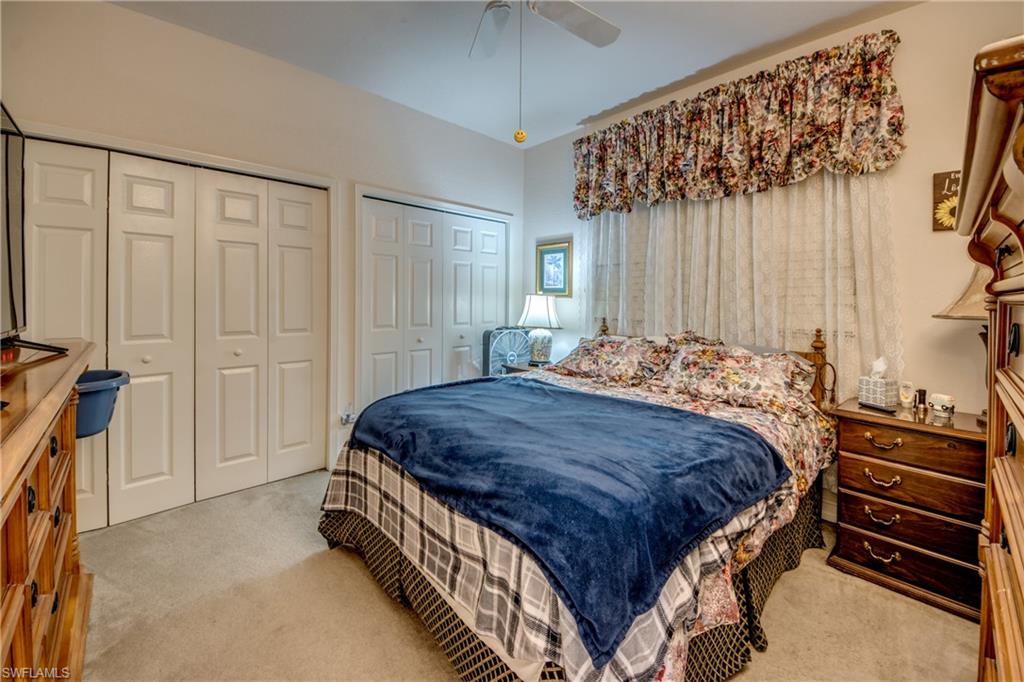 Carpeted bedroom featuring two closets and a ceiling fan