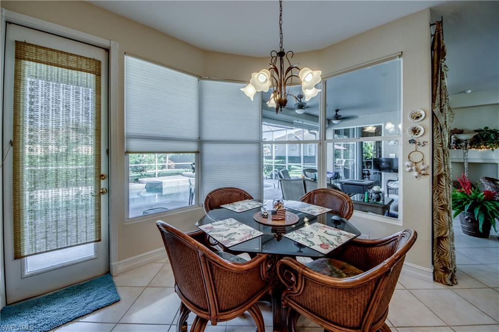 Dining area featuring a chandelier, light tile patterned floors, and a ceiling fan
