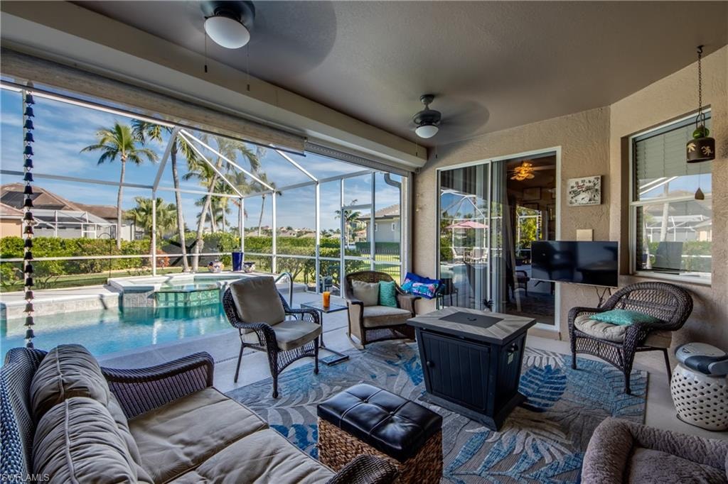 View of patio / terrace with ceiling fan, a sunroom, an outdoor living space, a lanai, and a pool with connected hot tub