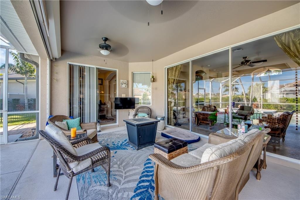 View of patio / terrace with a ceiling fan, a sunroom, outdoor lounge area, and glass enclosure