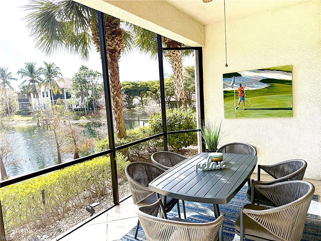 Sunroom featuring outdoor dining space and a water view