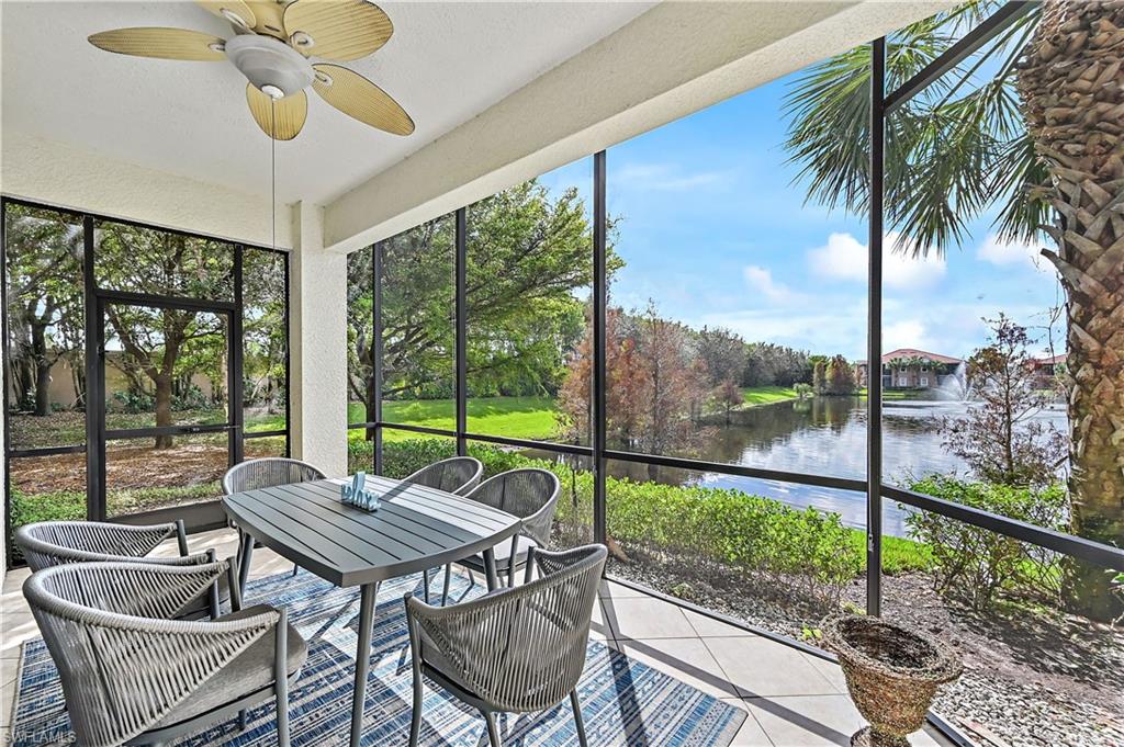 Sunroom featuring outdoor dining area, a water view, and ceiling fan