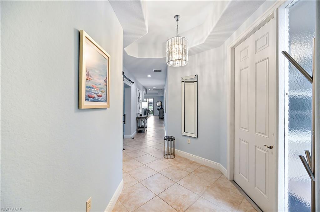 Corridor featuring a chandelier and light tile patterned floors