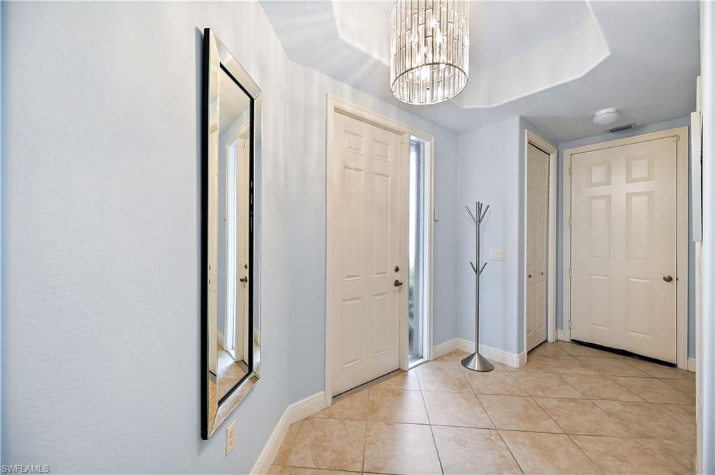 Foyer entrance with suspended lighting and light tile patterned floors