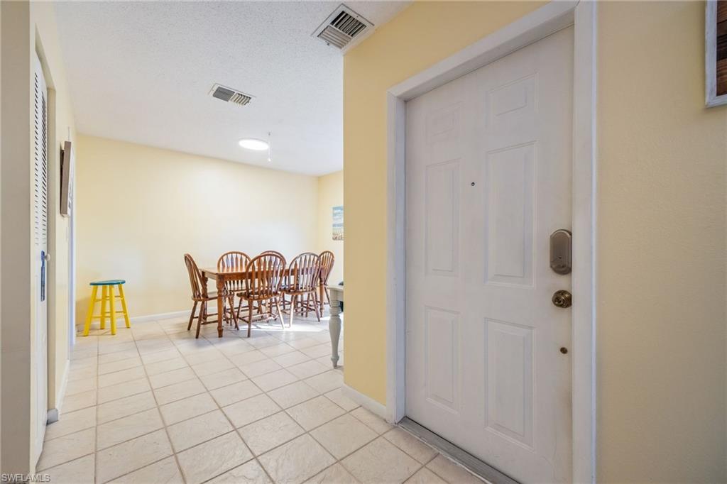 Entryway featuring light tile patterned flooring and a textured ceiling