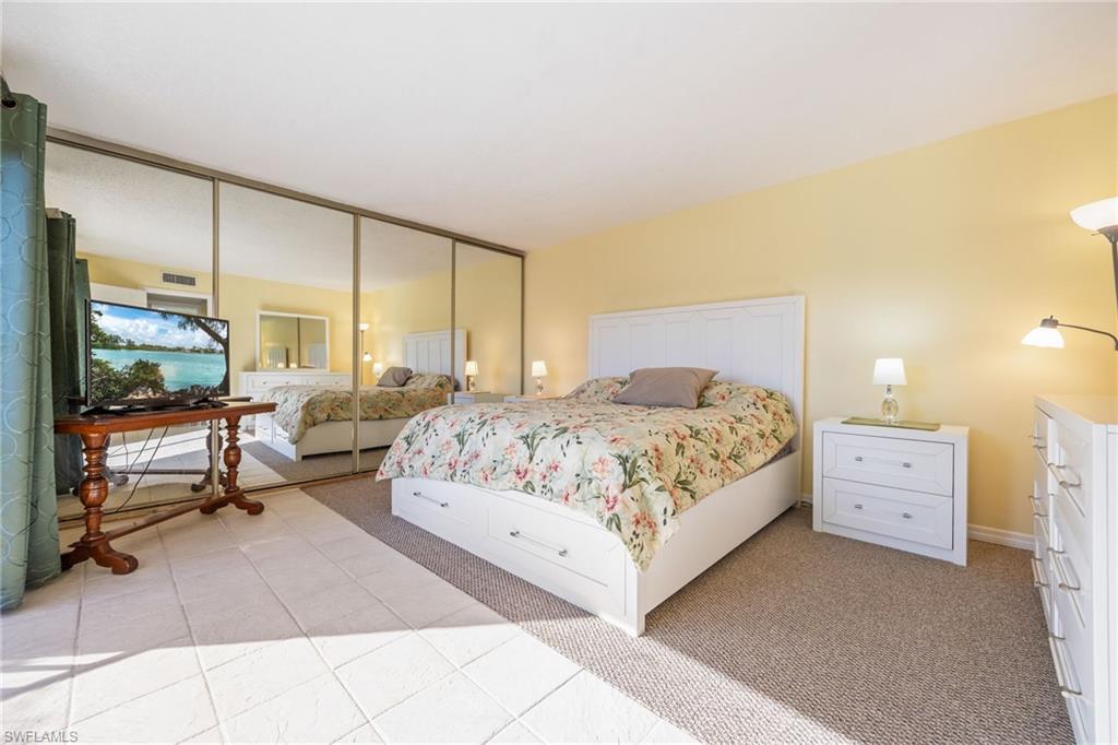 Bedroom featuring light carpet, a closet, and light tile patterned floors