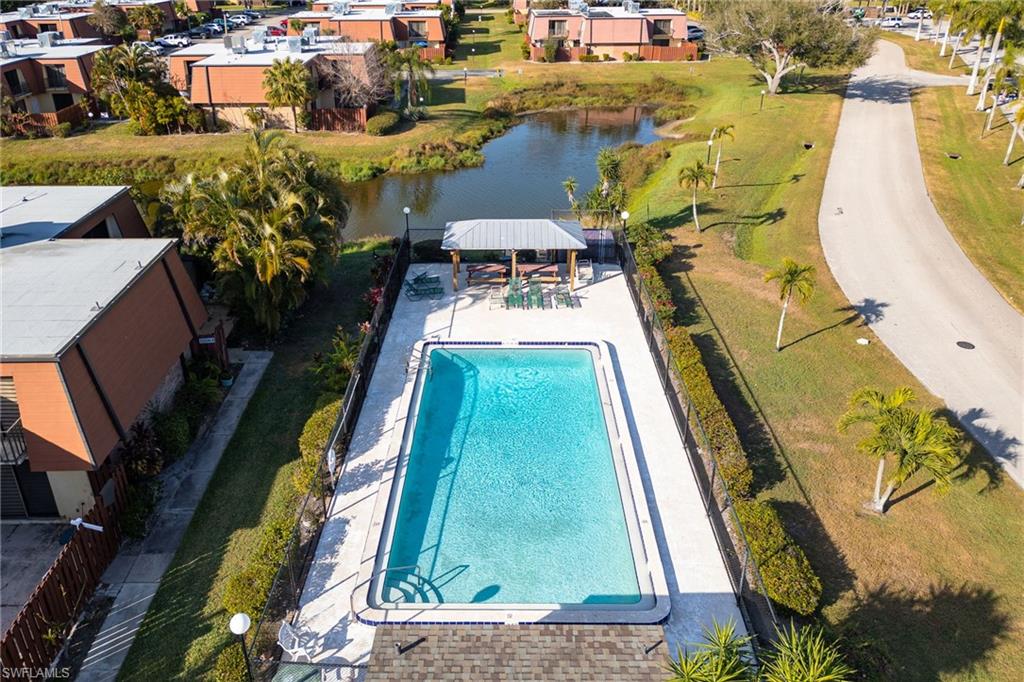 Drone / aerial view of a nearby body of water and a pool area