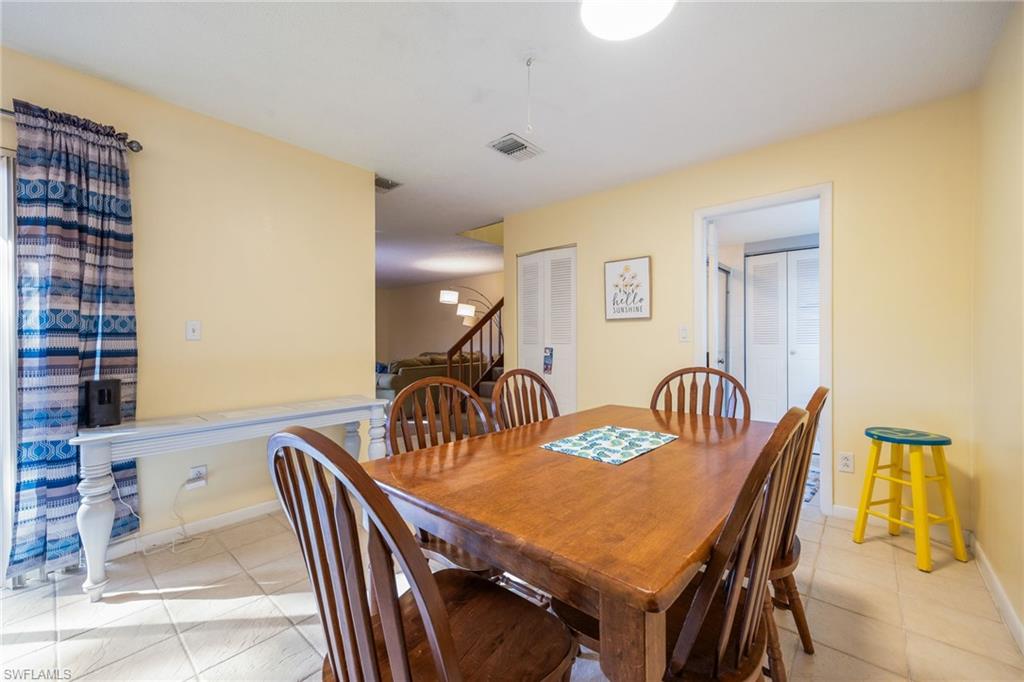 Dining space with stairs and light tile patterned floors