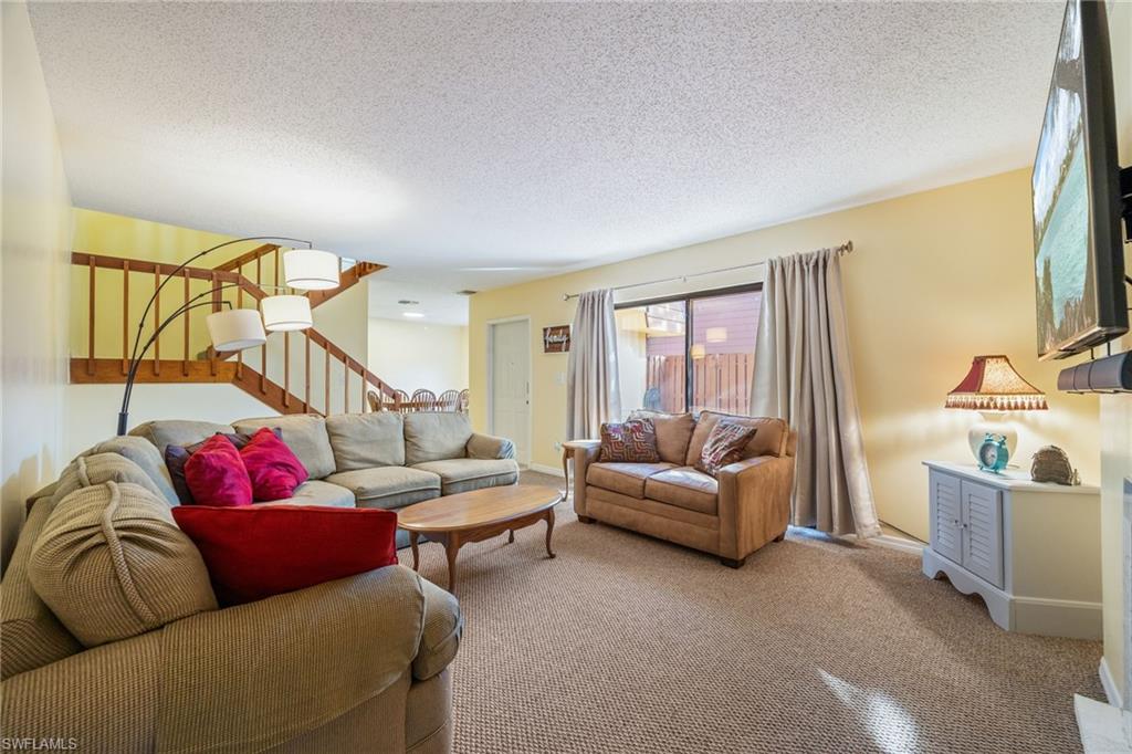 Carpeted living area featuring a textured ceiling
