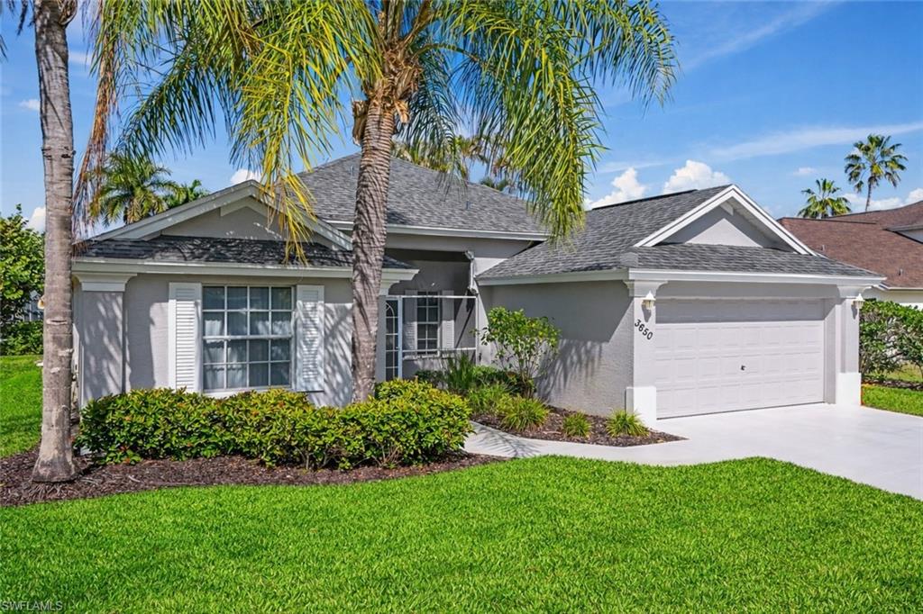 Ranch-style home featuring a front lawn, an attached garage, concrete driveway, and stucco siding