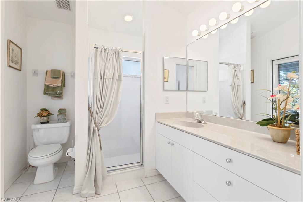Full bathroom with a shower stall, vanity, and light tile patterned flooring