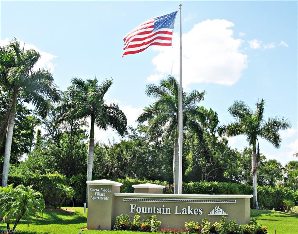 Community / neighborhood sign featuring a yard and view of wooded area