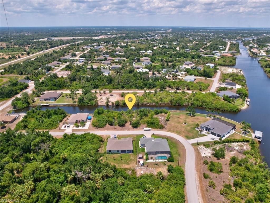 Aerial view of property and surrounding area with nearby suburban area and a nearby body of water