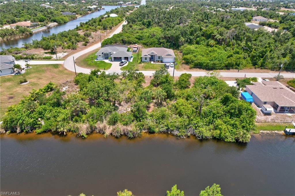 Aerial overview of property's location with a nearby body of water and a tree filled landscape