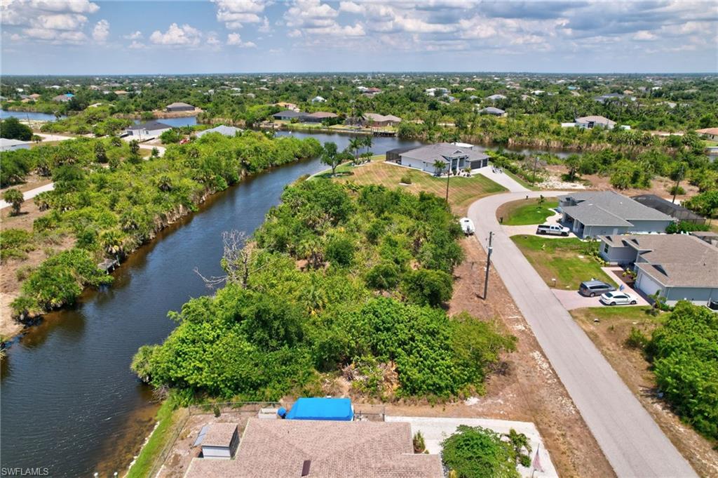 Aerial overview of property's location featuring a nearby body of water and nearby suburban area