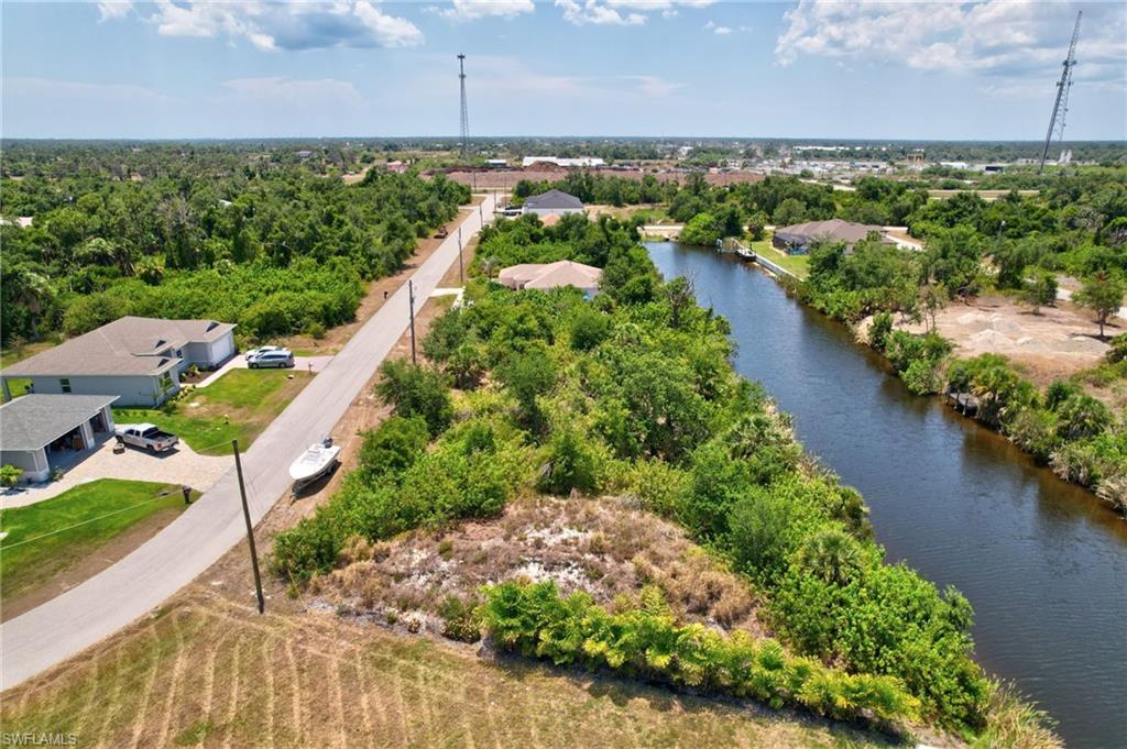 Aerial view of property's location featuring a nearby body of water and a tree filled landscape