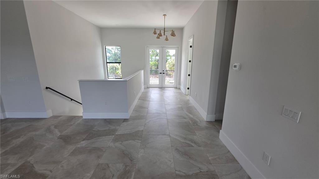 Sleek tile flooring, white walls, and a contemporary chandelier