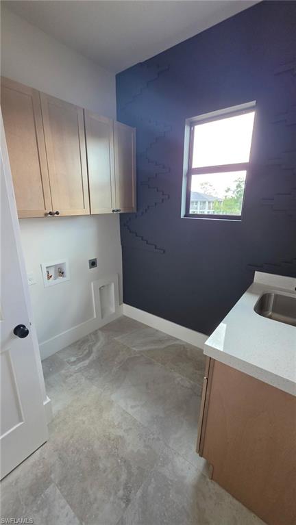 Light wood-finish cabinetry, solid surface countertop with integrated sink, and large format tile flooring