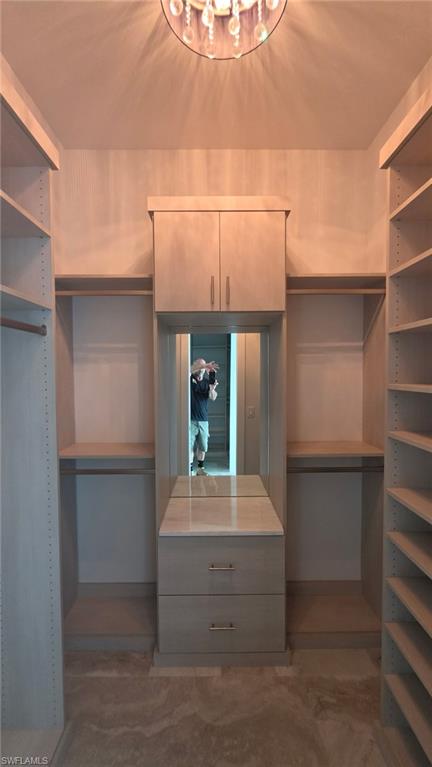 Built-in custom cabinetry with shelving, hanging rods, and an integrated mirror