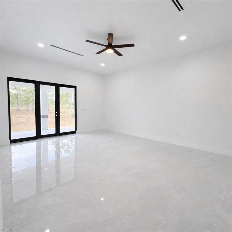 Unfurnished room with a ceiling fan, recessed lighting, and french doors
