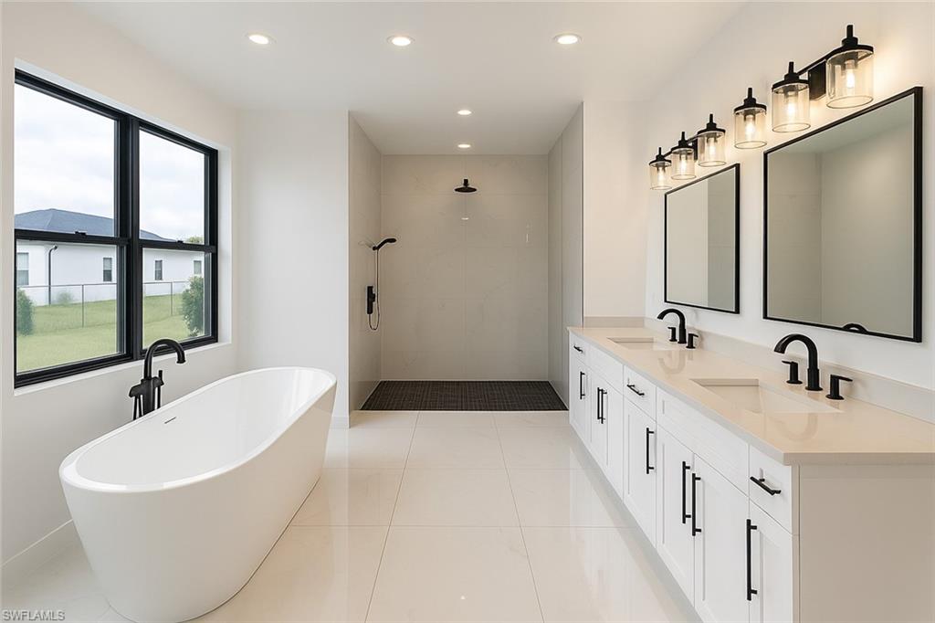 Full bath featuring a freestanding bath, a tile shower, recessed lighting, double vanity, and light tile patterned floors