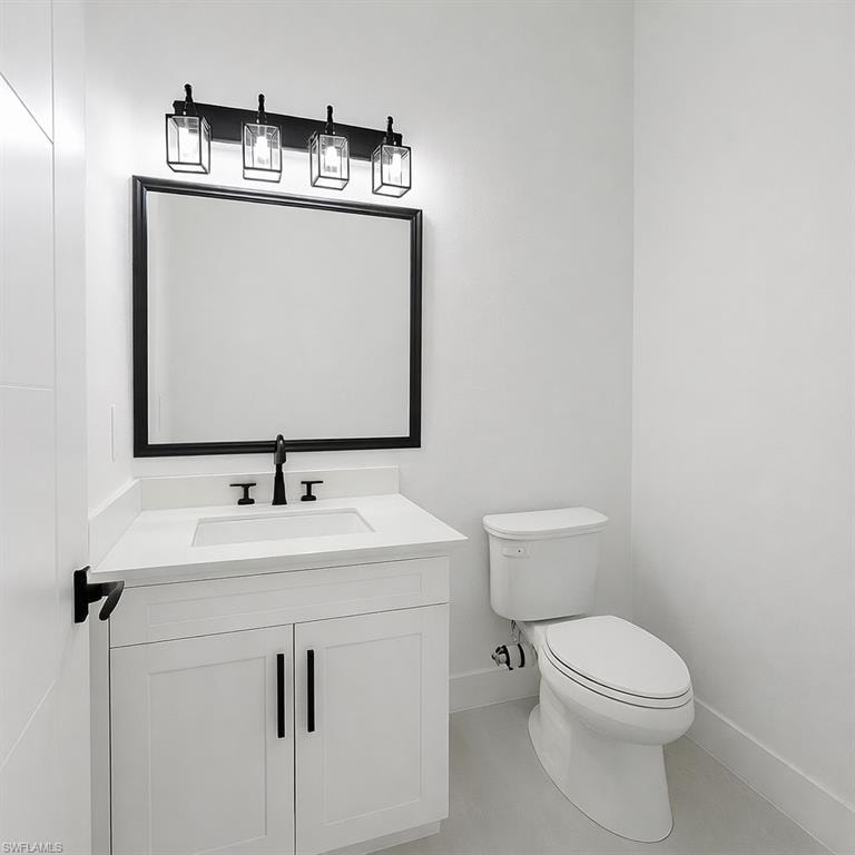 Half bathroom featuring vanity and toilet