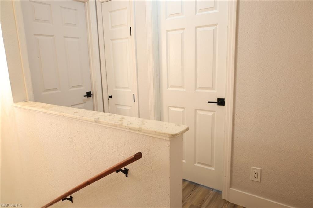 Stairs featuring a textured wall and wood finished floors