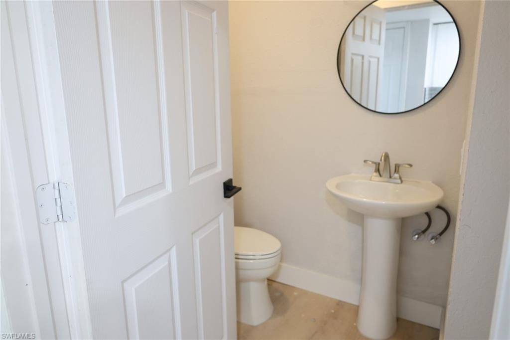 Half bath with toilet and baseboards