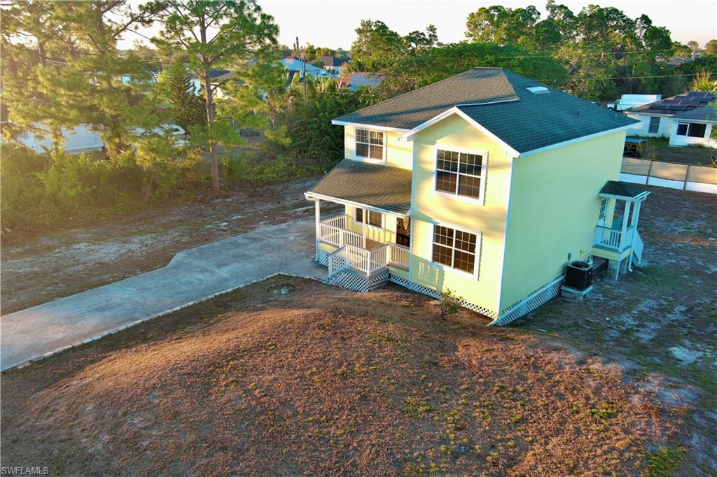 View of front of house featuring a shingled roof, a porch, and concrete driveway
