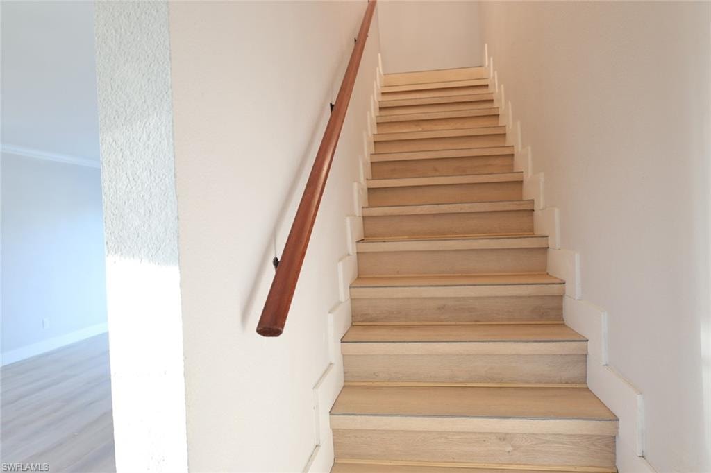 Stairs featuring wood finished floors and baseboards