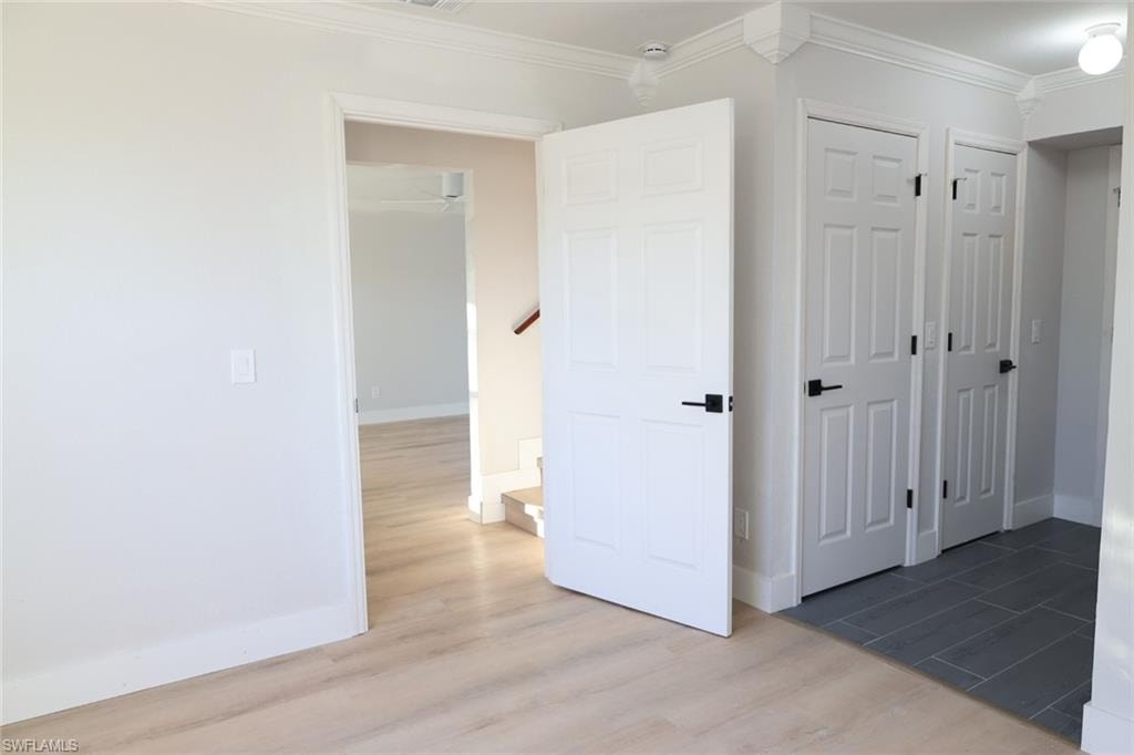 Unfurnished bedroom featuring wood finished floors and ornamental molding