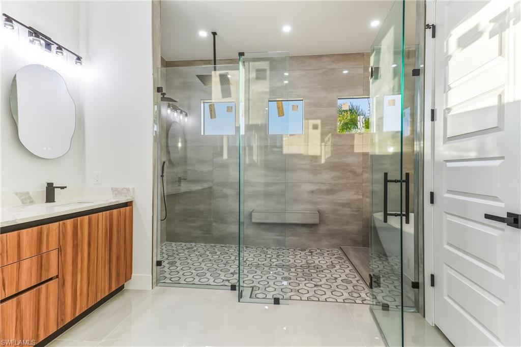 Full bath with vanity, a stall shower, recessed lighting, and light tile patterned floors