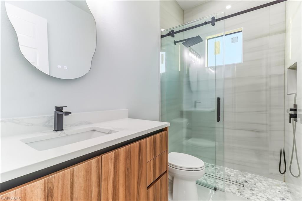 Full bathroom featuring a glass shower stall and vanity