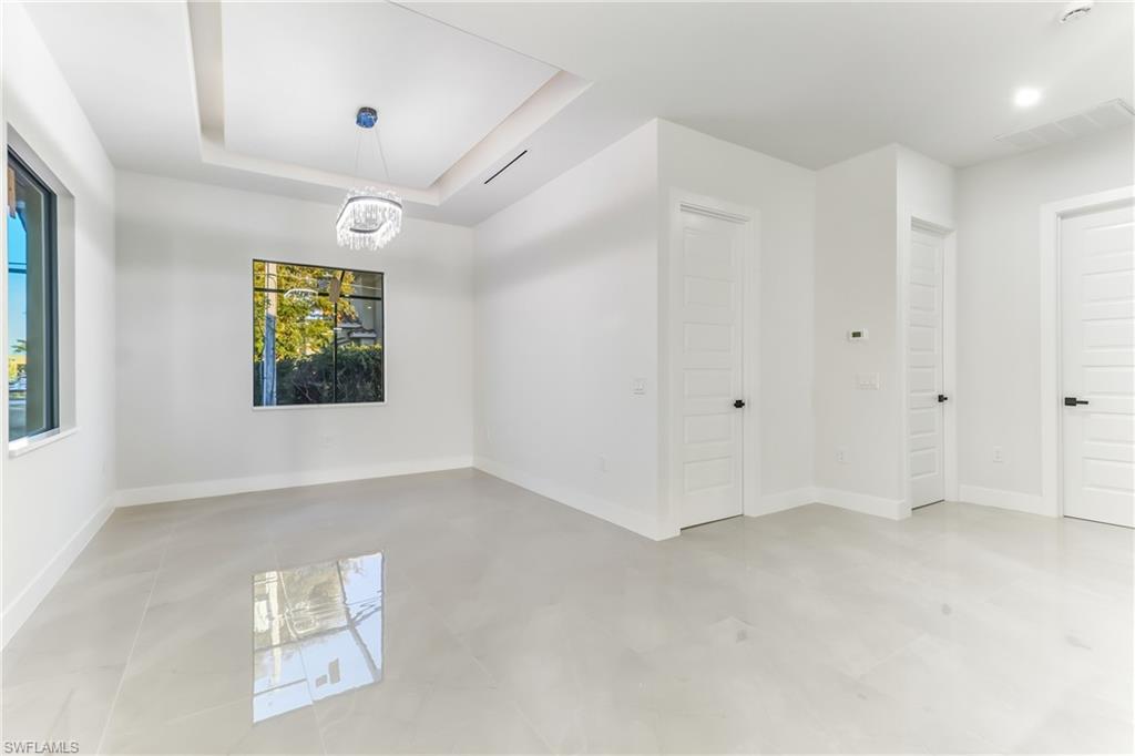 Spare room with a raised ceiling and suspended lighting