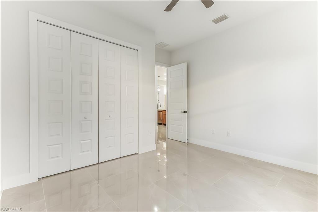 Unfurnished bedroom featuring a closet and ceiling fan