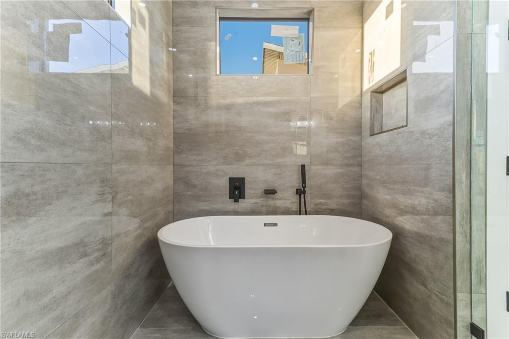Bathroom featuring tile walls and a freestanding bath