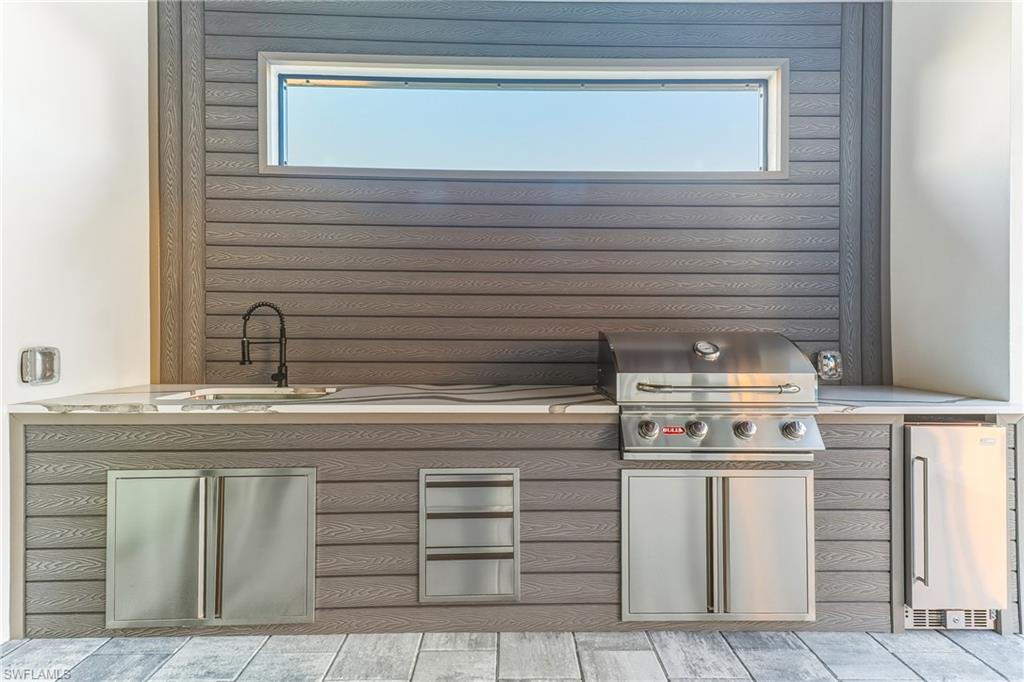 Kitchen featuring stainless steel drink fridge and a sink