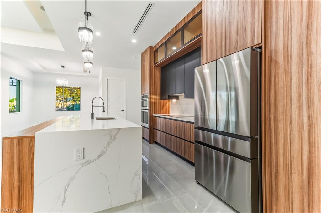 Kitchen featuring modern cabinets, stainless steel appliances, and wood finish cabinets