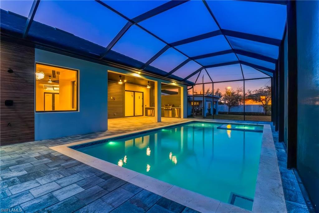 Pool at dusk with an outdoor pool, a patio area, screened enclosure pool cage
