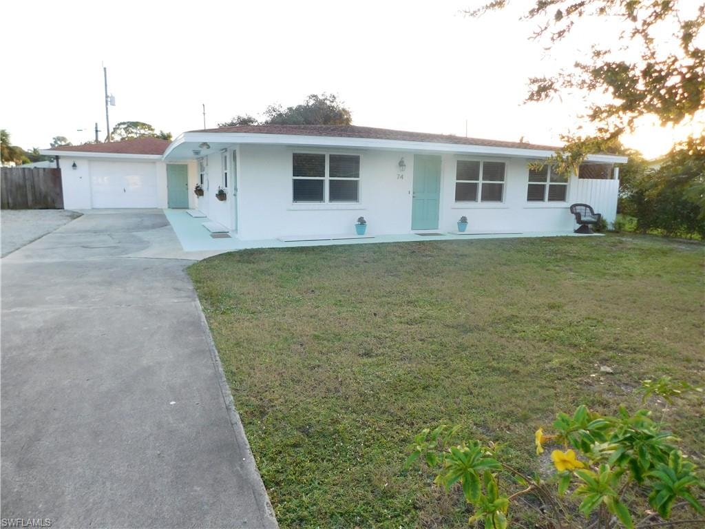 Ranch-style house with driveway and stucco siding