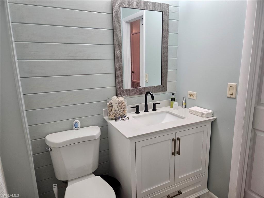 Half bath featuring toilet and vanity